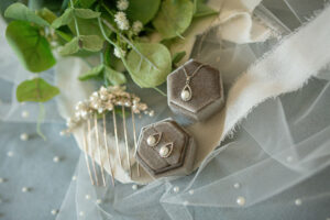 A pearl necklace earring set and a bridal veil comb.