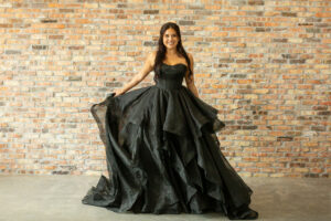 A bride modeling a black wedding dress.