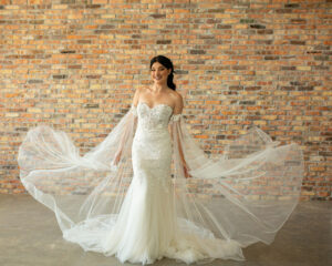 A bride modeling a lace sleeve wedding dress.