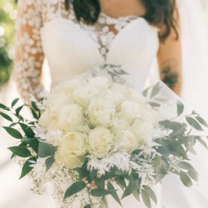 A bride in a white bridal dress holding a bouquet.