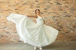 Riverview, FL bride to be twirling in her satin, a line wedding dress with a cummberbund like piece on bodice.