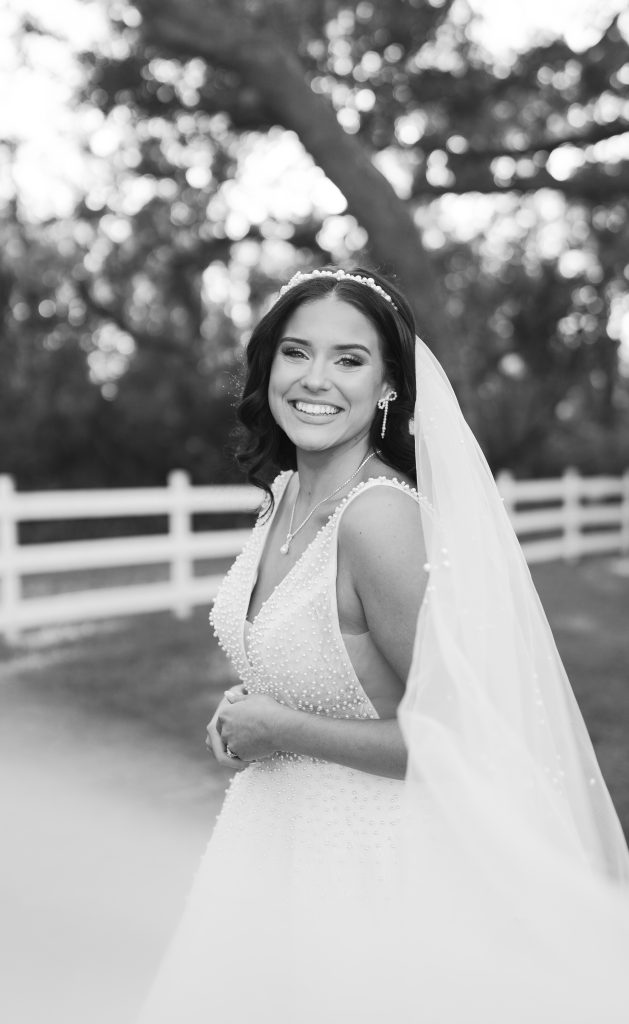 Bow earrings with pearls paired with a stunning wedding dress, captured by photographer Melanie Shirley for a Valentine’s-themed wedding in Riverview, FL. A delicate and elegant accessory that perfectly complements the romantic bridal look.